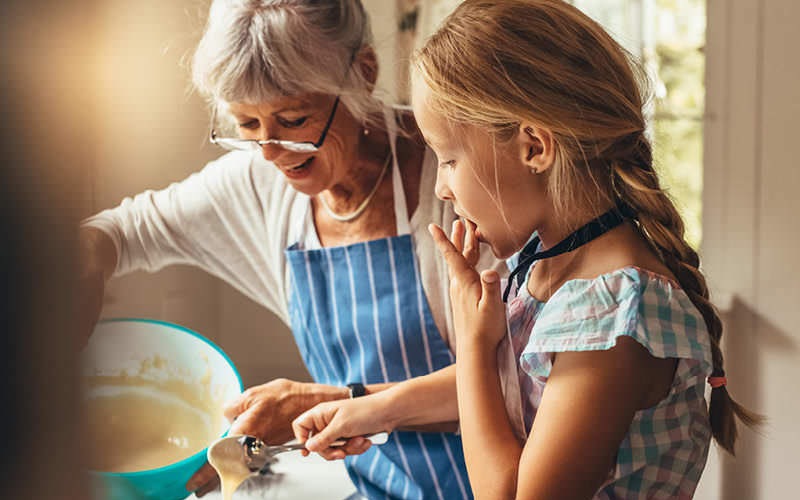 	grandmother and granddaughter bake together